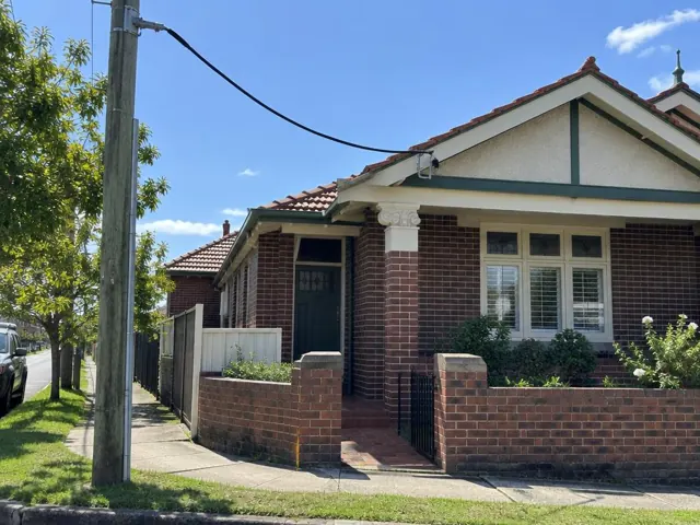 Brick house exterior with overhead service cable and point-of-attachment bracket on the gable in Broadmeadow